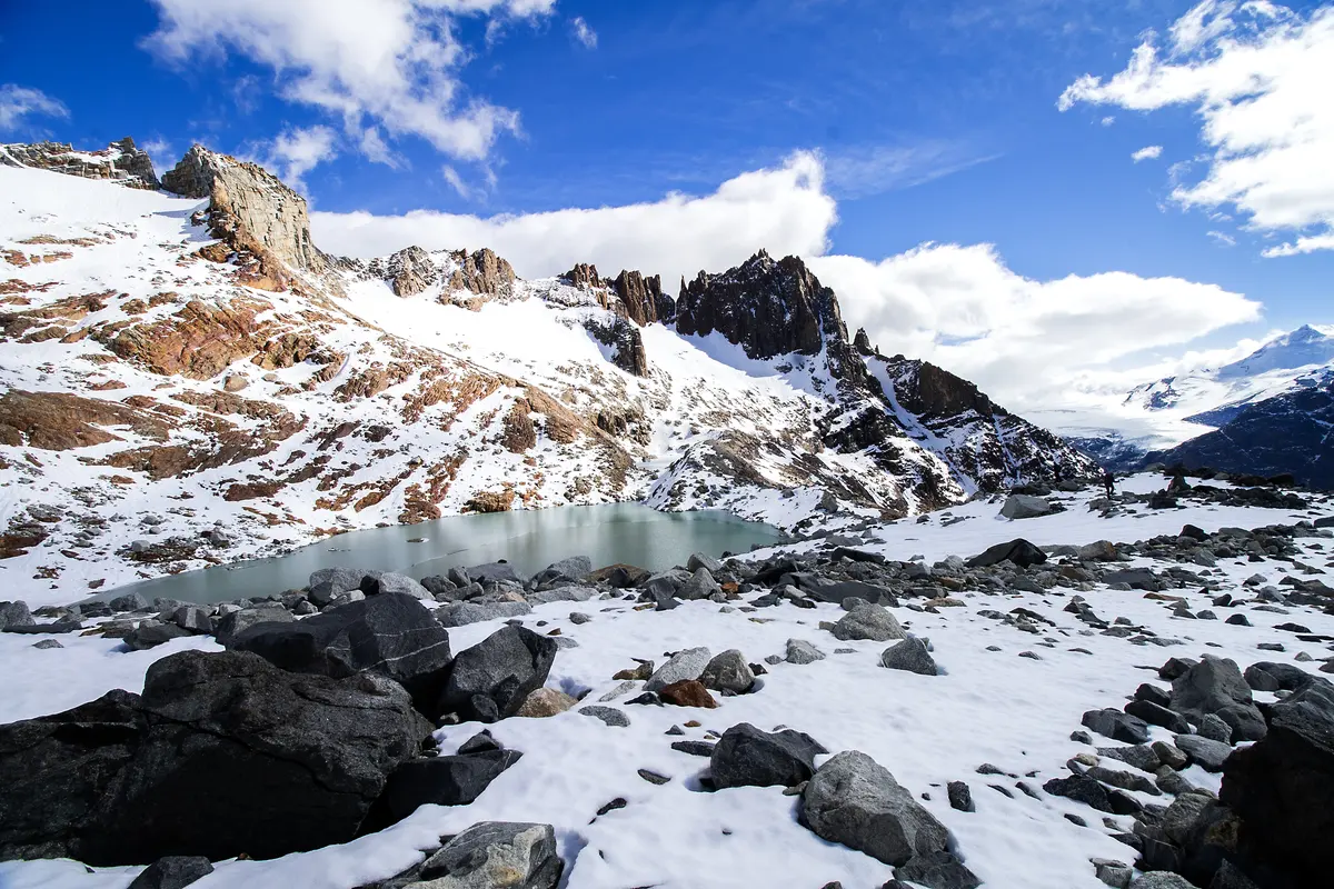 Una laguna entre piedras y nieve