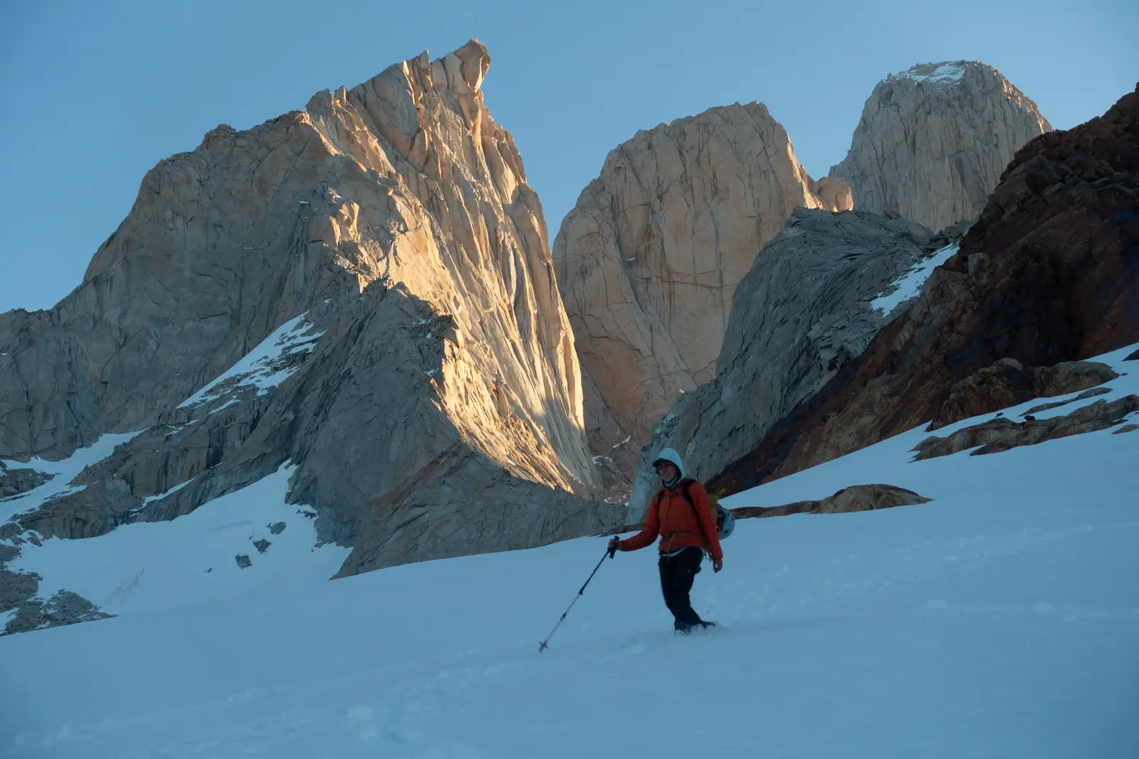 Caminando sobre la nieve, con las paredes del macizo al primer sol