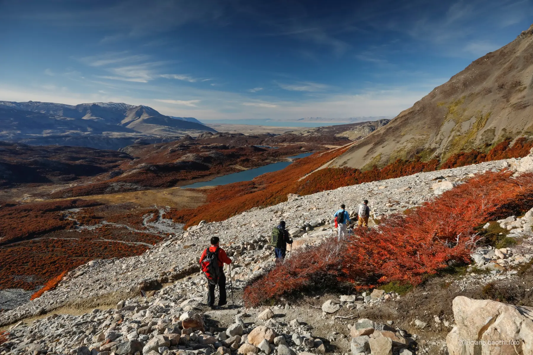 Hikers descending through a remote autumn valley in Patagonia